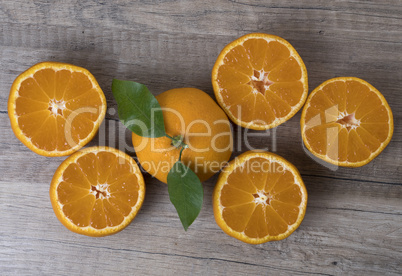 Fresh ripe tangerines with leaves on a wooden background. Fresh ripe tangerines with leaves on a wooden background.