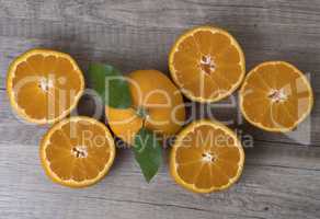 Fresh ripe tangerines with leaves on a wooden background.