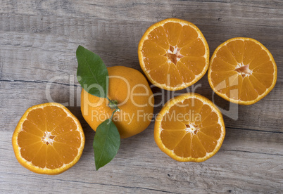 Fresh ripe tangerines with leaves on a wooden background. Fresh ripe tangerines with leaves on a wooden background.