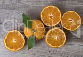 Fresh ripe tangerines with leaves on a wooden background.