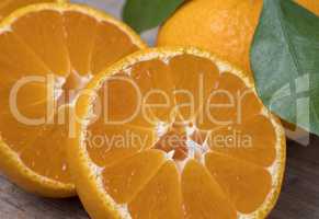 Fresh ripe tangerines with leaves on a wooden background.