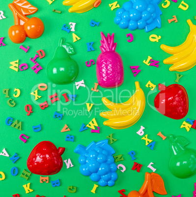 green background with childrens plastic toys and wooden multico