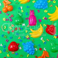 green background with childrens plastic toys and wooden multico