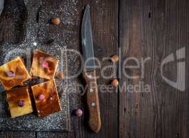 pieces of cheesecake with pumpkin on brown wooden cutting board