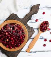 red berries of ripe lingonberries in a wooden bowl