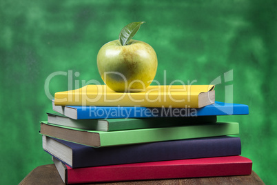 Apple fruit on top of a book stack, on the back of school classes.