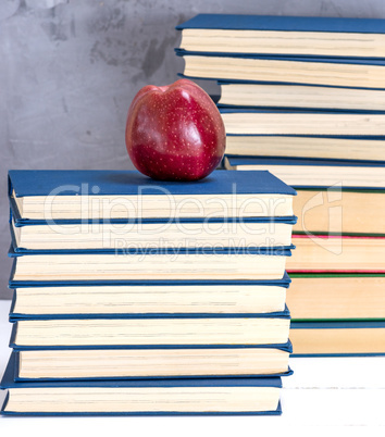 ripe red apple on a stack of books