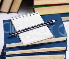 empty notebook with white sheets and a black pencil