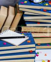 empty notebook with white sheets and many different books