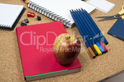 School elements on cork background with space for text symbolizing back to school