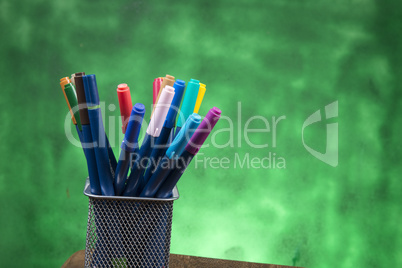 Creativity of Colorful Colored Pen in Pencil Case with Copy Space on Blurred Bokeh green Background