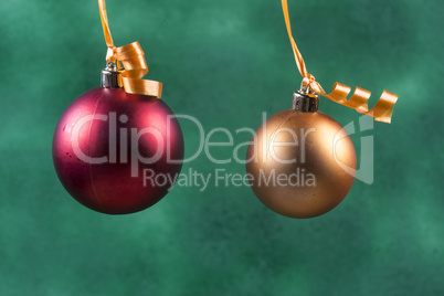 red christmas ball hanging with orange ribbon on green background