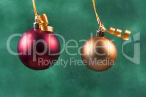 red christmas ball hanging with orange ribbon on green background