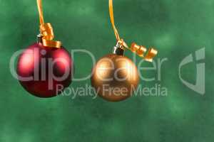 red christmas ball hanging with orange ribbon on green background