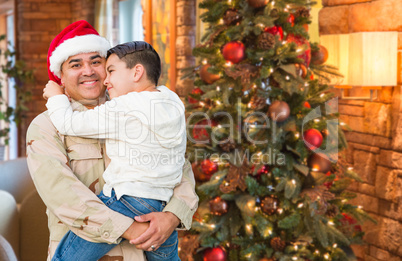 Hispanic Armed Forces Soldier Wearing Santa Hat Hugging Son