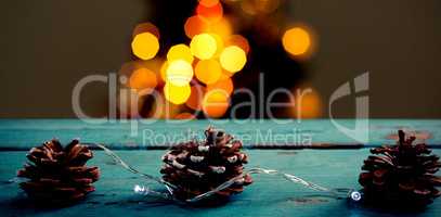 Composite image of pine cones decorated with christmas light