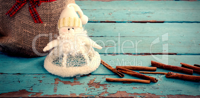 Composite image of cinnamon sticks and christmas decoration by sack on wooden table