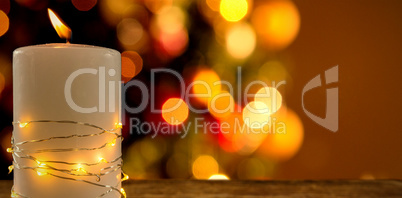 Composite image of illuminated string lights wrapped on lit candle