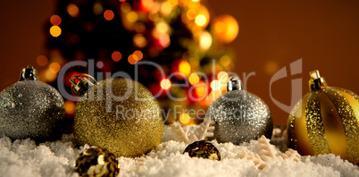 Composite image of christmas balls lying in the snow