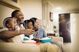 Cheerful family having popcorn while watching television