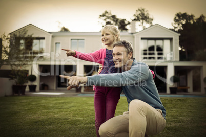 Father and daughter pointing in the garden