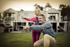 Father and daughter pointing in the garden