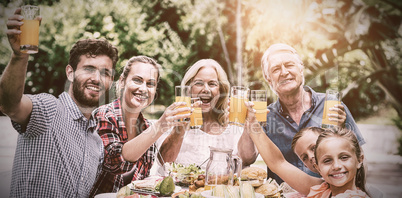 Family having breakfast at table in yard