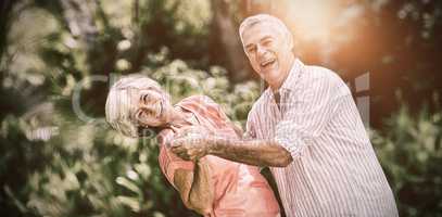Senior couple enjoying while dancing in yard