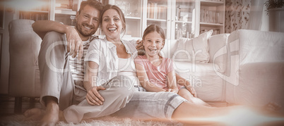 Happy family sitting on rug in living room