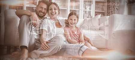 Happy family sitting on rug in living room