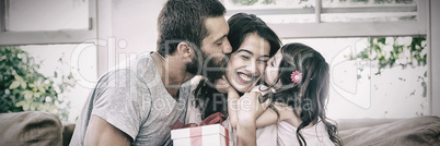 Mother receiving gift from her husband and daughter