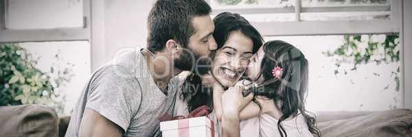 Mother receiving gift from her husband and daughter