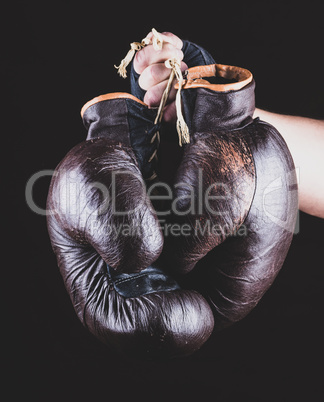 pair of leather sports boxing gloves in hand