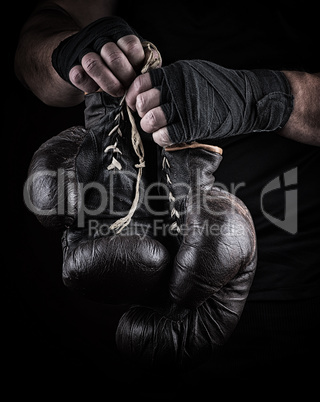 very old boxing sports gloves in men's hands