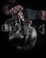 very old boxing sports gloves in men's hands