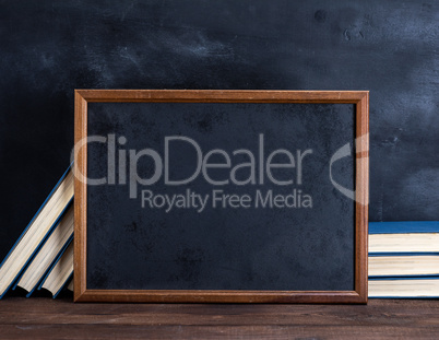 empty black chalk drawing frame and stack of books