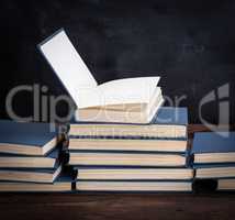 stack of various books, open book on top