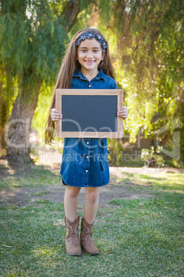 Cute Young Mixed Race Girl Holding Blank Blackboard Outdoors