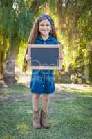 Cute Young Mixed Race Girl Holding Blank Blackboard Outdoors
