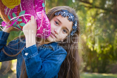 Cute Young Mixed Race Girl Holding Mylar Balloon Outdoors
