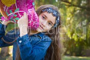 Cute Young Mixed Race Girl Holding Mylar Balloon Outdoors