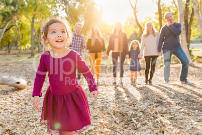 Mixed Race Baby Girl Outdoors with Family Behind