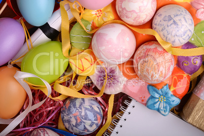 Handcrafted easter eggs close up, white notepad, ribbons and decoration