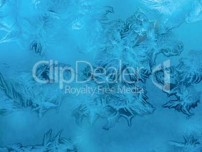 beautiful Christmas frosty pattern with white snowflakes on blue background on window