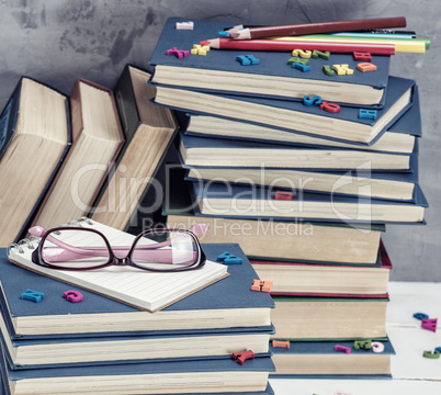 stack of books in a blue cover, pink glasses on top