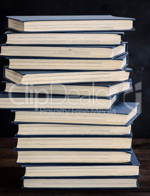 stack of books in a blue cover on a brown wooden table