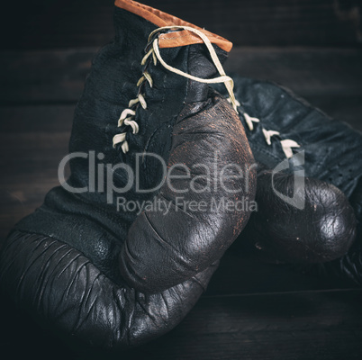 pair of very old shabby black leather boxing gloves