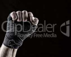 lifted up fist of athlete wrapped in black textile bandage