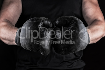 hands of an athlete in black old sport boxing gloves