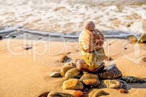 Zen stone pyramid at a beach with surf